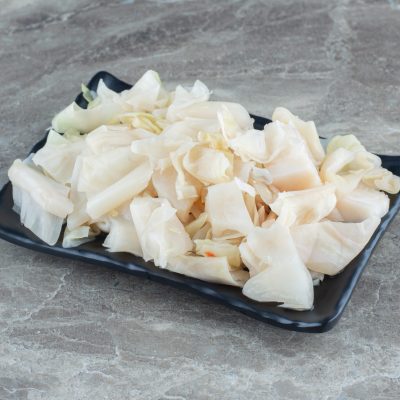 Chopped cabbage pickle on black plate. High quality photo